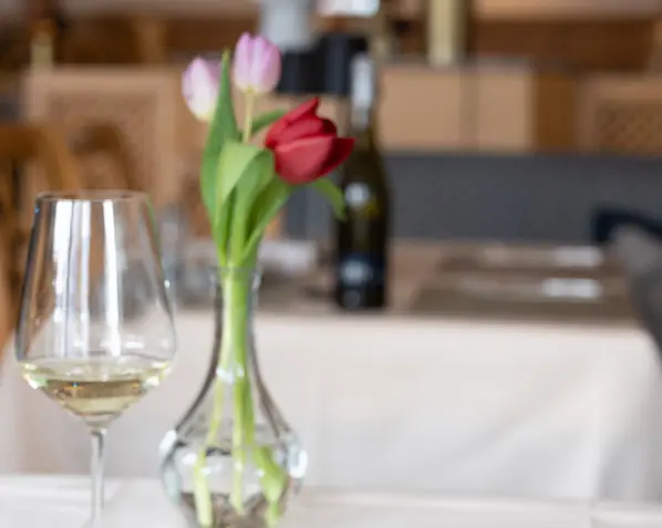 Gemütlich gedeckter Tisch im Parkhotel mit Geburtstagskuchen, Kerzen und floraler Dekoration – ideal für besondere Geburtstagswünsche.