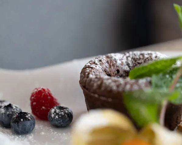 Gemütlich gedeckter Tisch im Parkhotel mit Geburtstagskuchen, Kerzen und floraler Dekoration – ideal für besondere Geburtstagswünsche.